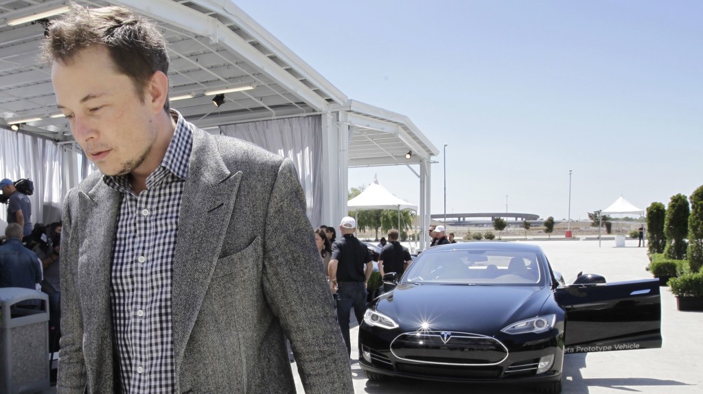 Tesla CEO Elon Musk walks past the Tesla Model S after a news conference at the Tesla factory in Fremont, Calif., Friday, June 22, 2012.</span> <span class=