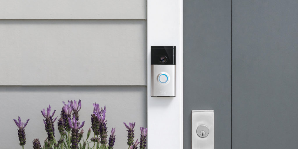 Photo d'une sonnette connectée Ring sur le pas d'une porte de maison.