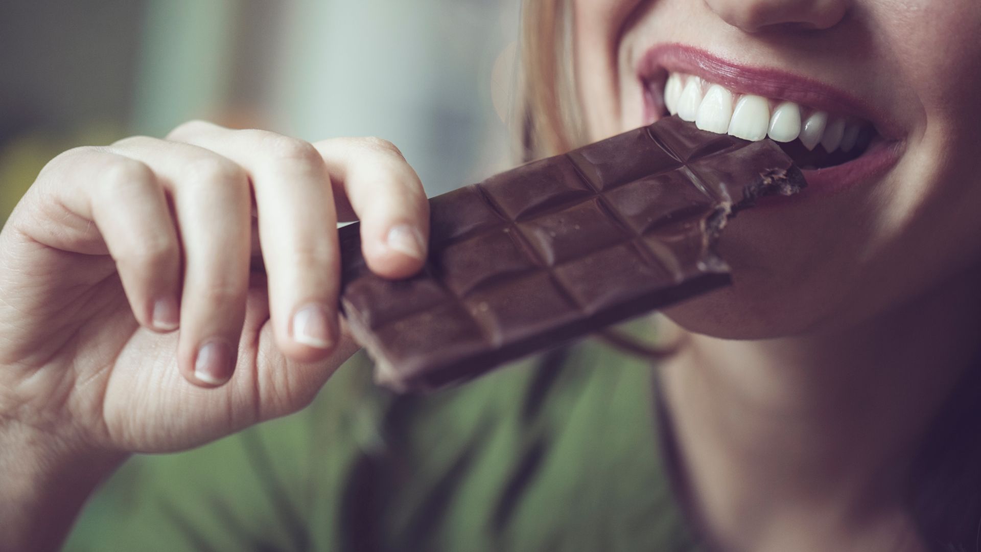 Сняли шоколадку. Девушка с шоколадкой. Ест шоколад. Шоколадка в руке девушки.